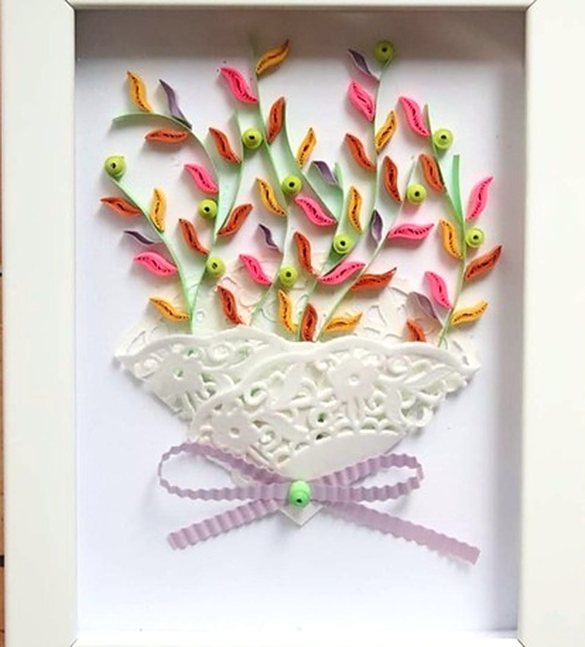 Beyaz çerçevede dantel desenli beyaz vazoda pastel yapraklı quilling buket ve lila kurdele