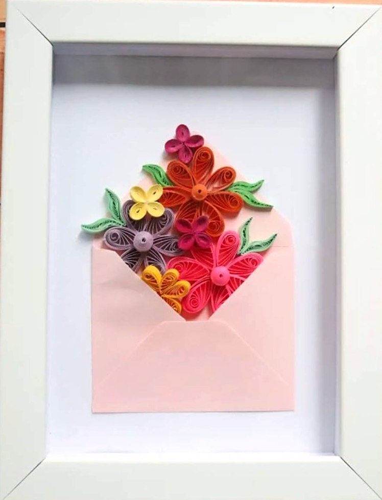 Beyaz çerçevede pembe zarftan taşan renkli quilling çiçekler